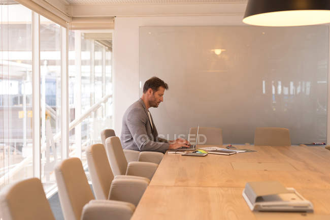 Бизнесмен использует ноутбук в конференц-зале в офисе — стоковое фото