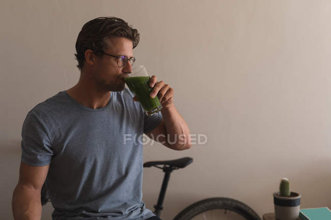 Uomo che ha un succo di dieta in soggiorno a casa — Foto stock