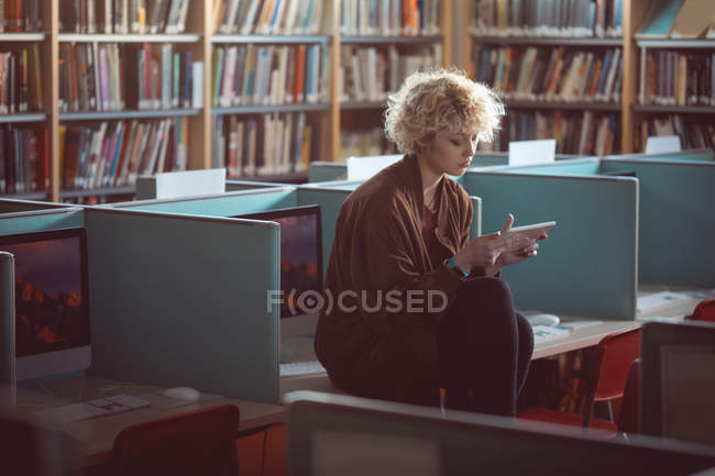 Junge Frau nutzt digitales Tablet in Bibliothek — Stockfoto
