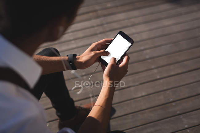 Empresario usando teléfono móvil en oficinas en un día soleado - foto de stock