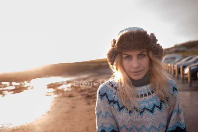 Retrato de la mujer de pie en una playa al atardecer - foto de stock