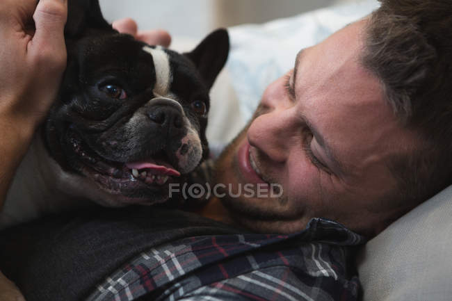 Homem com buldogue francês cão em casa na cama — Fotografia de Stock