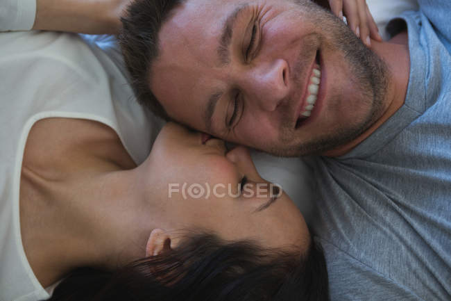 Couple lying on bed in bedroom at home — Stock Photo