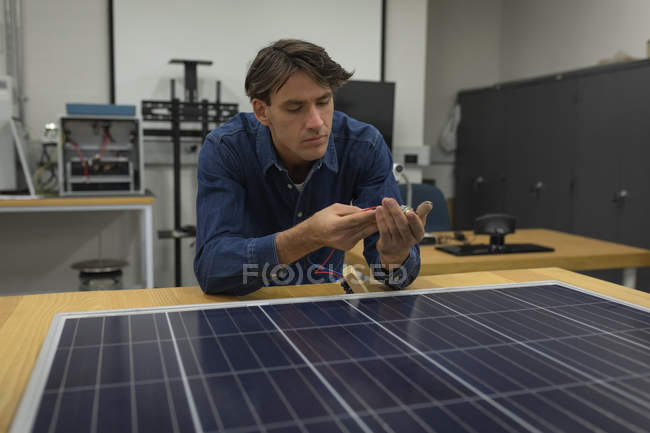 Чоловік працює на сонячній панелі в офісі — стокове фото
