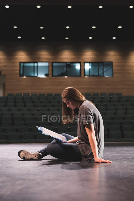 Female actress reading script on stage at theatre — Stock Photo