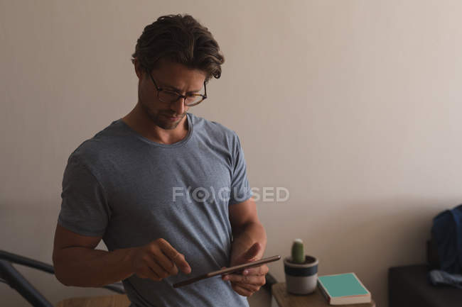 Man using digital tablet in living room at home — Stock Photo