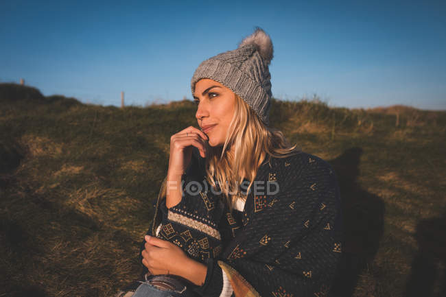 Mulher atenciosa em xale relaxante perto da praia — Fotografia de Stock