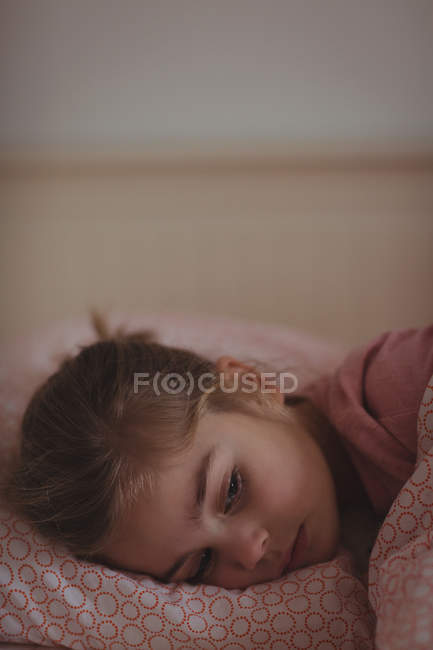 Маленькая девочка спит на кровати в спальне дома — стоковое фото