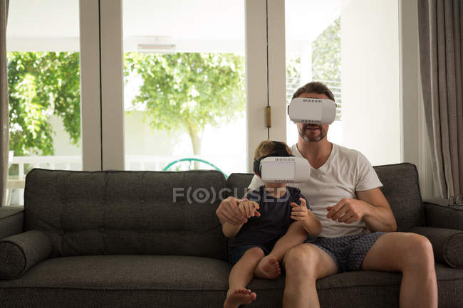 Отец и сын, используя цифровой планшет в гостиной на дому — стоковое фото