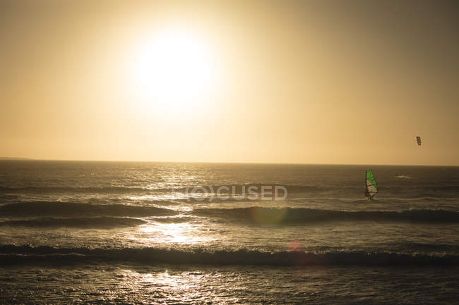 Surfer surfen mit Surfbrett und Kite am Strand — Stockfoto