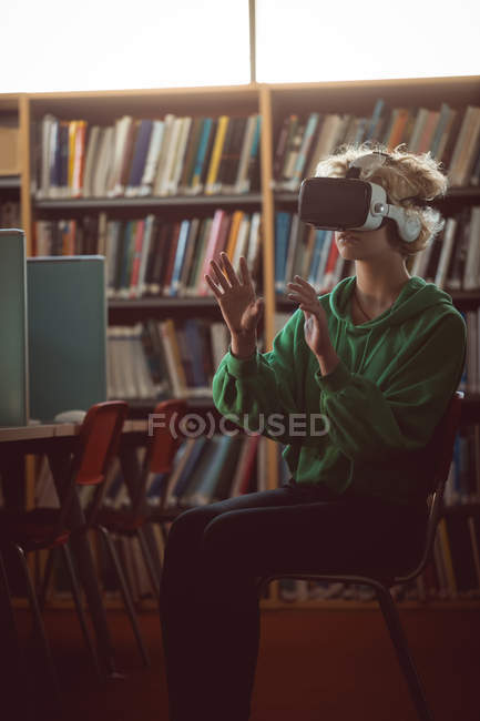 Giovane donna utilizzando auricolare realtà virtuale in biblioteca — Foto stock