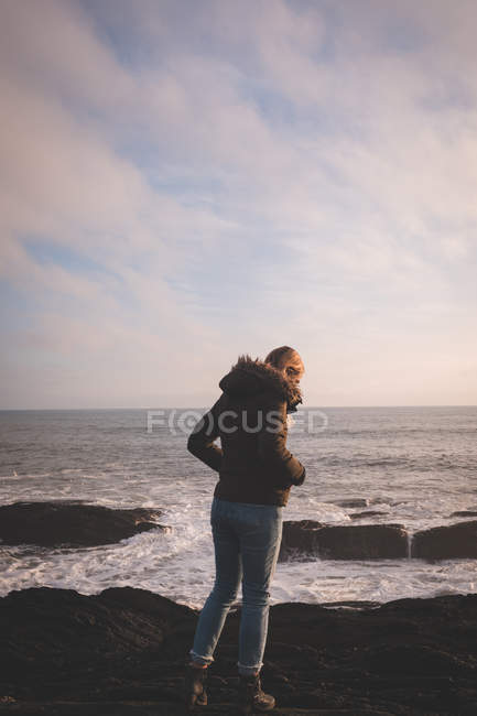 Вид ззаду жінки, що стоїть на пляжі — стокове фото