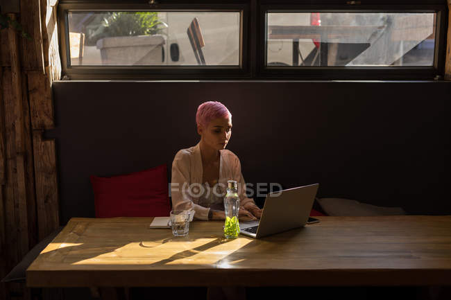 Stilvolle Frau benutzt Laptop im Restaurant — Stockfoto