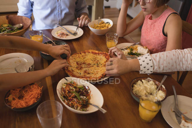 Famiglia che mangia pizza in cucina a casa — Foto stock