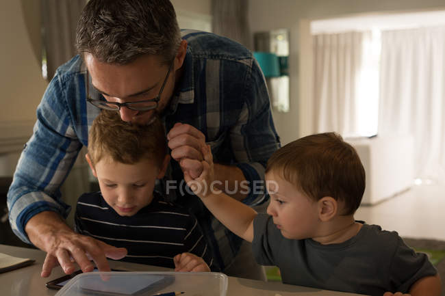 Батько і його сини використовують цифровий планшет вдома — стокове фото