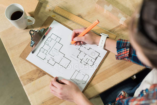 Tischlerin zeichnet in Werkstatt einen Plan auf Klemmbrett — Stockfoto