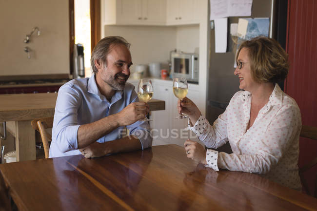Casal brindar copos de champanhe na cozinha em casa — Fotografia de Stock