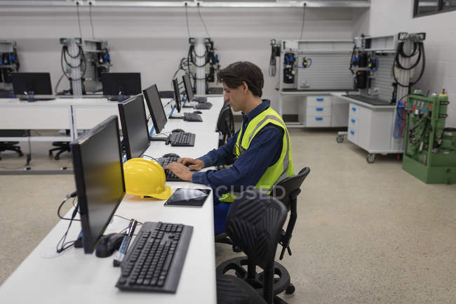 Чоловік працює на комп'ютері в офісі сонячної станції — стокове фото