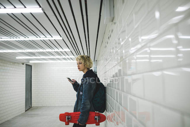 Junge Frau benutzt Handy in U-Bahn — Stockfoto