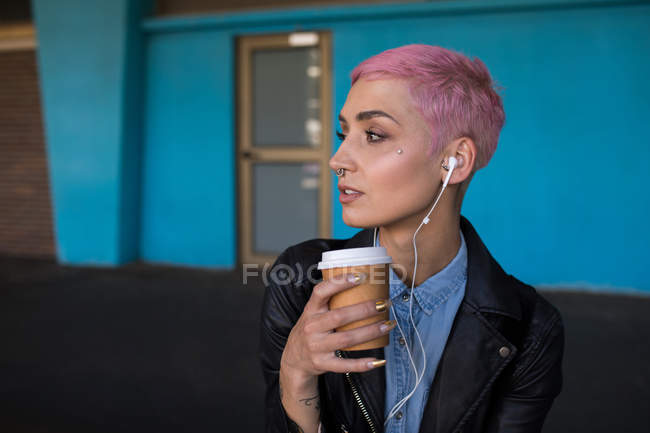 Стильна жінка має каву під час очікування на залізничній станції — стокове фото