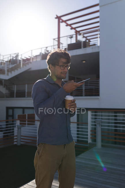 Hombre hablando por teléfono móvil en el balcón en casa - foto de stock