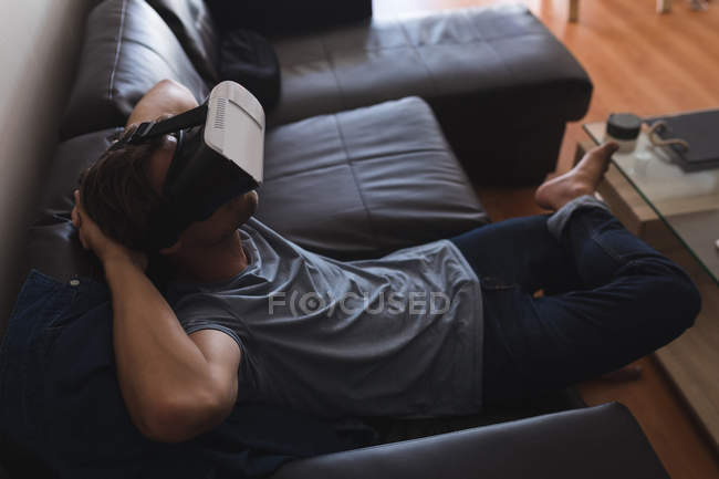 Homem usando fone de ouvido realidade virtual na sala de estar em casa — Fotografia de Stock
