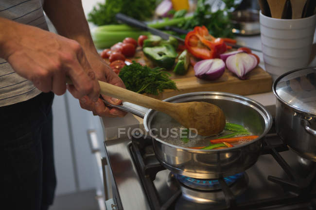 Man cooking food in kitchen at home — Stock Photo