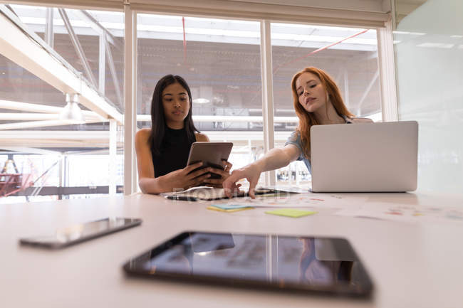 Женщины-руководители используют цифровой планшет и ноутбук на рабочем столе в офисе — стоковое фото