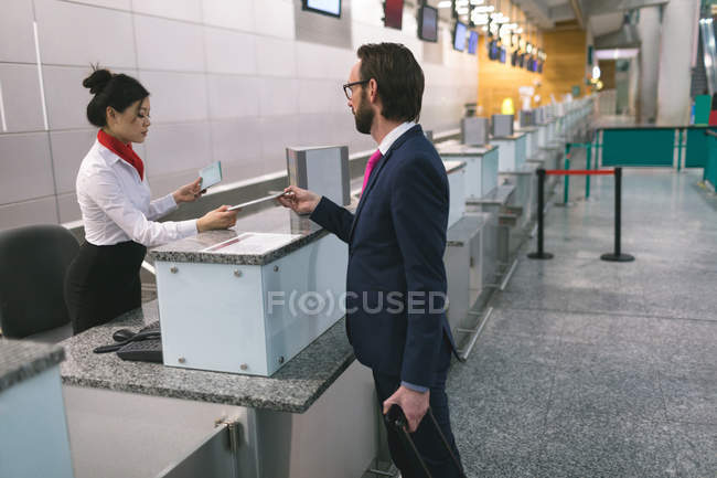 Реєстрація авіакомпанії передача цифрового планшета на лічильник в терміналі аеропорту — стокове фото