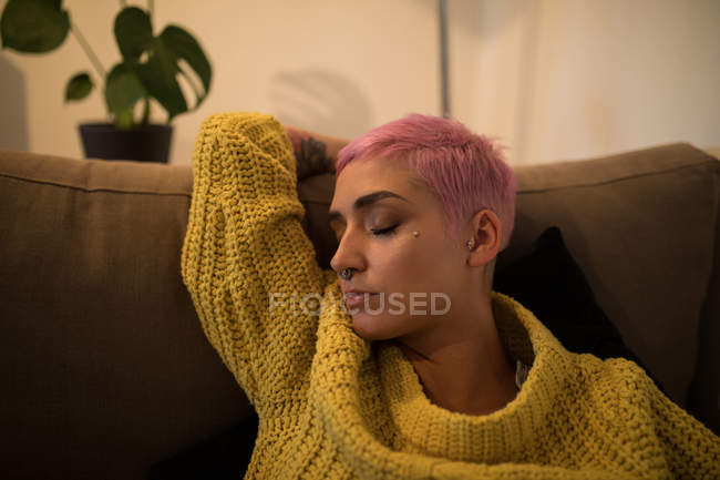 Стильна жінка спить на дивані у вітальні вдома — стокове фото
