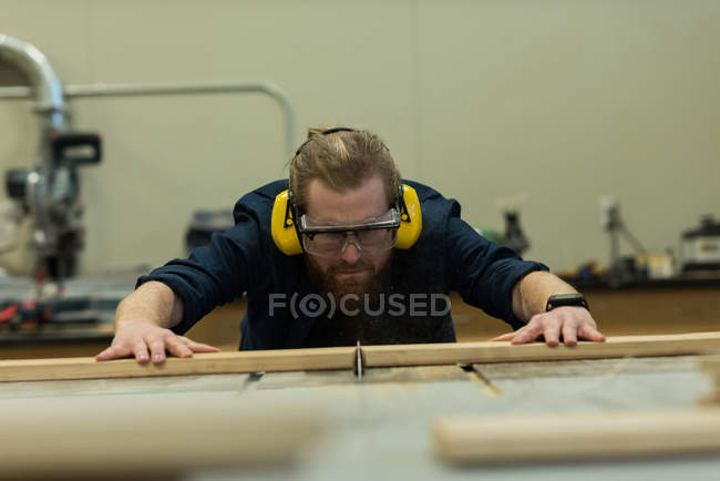 Menuisier mâle prenant des mesures de bois à l'atelier — Photo de stock