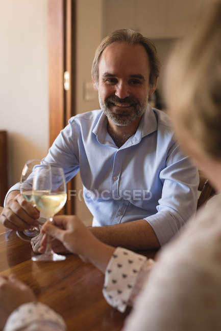 Couple toasting glasses of champagne in kitchen at home — Stock Photo