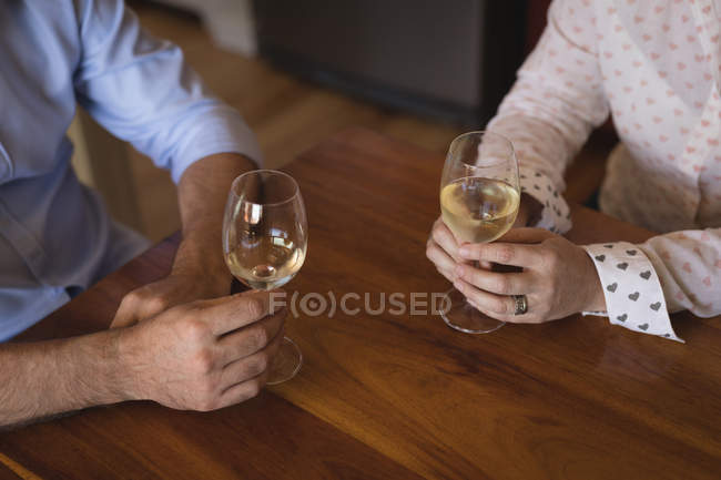 Partie médiane du couple ayant champagne dans la cuisine à la maison — Photo de stock