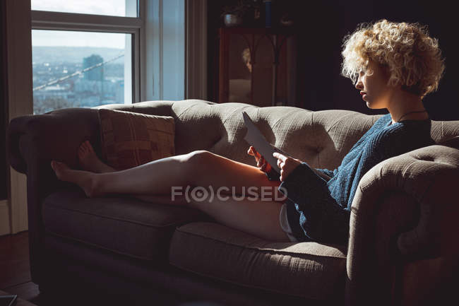 Женщина читает книгу в гостиной дома — стоковое фото