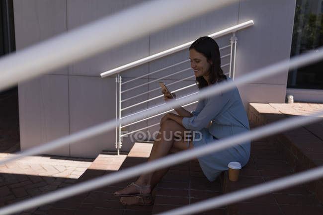 Mujer joven utilizando el teléfono móvil al aire libre - foto de stock