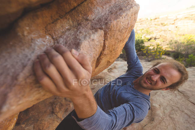 Male hiker climbing rocky mountain in countryside on a sunny day — Stock Photo