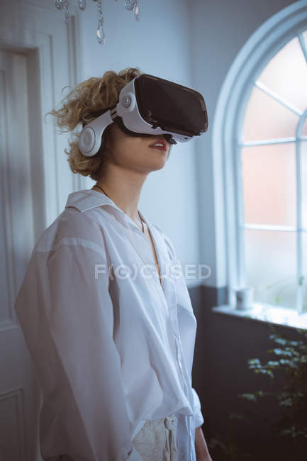 Молода жінка використовує гарнітуру віртуальної реальності вдома — стокове фото