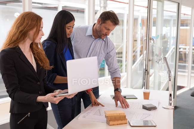 Бізнес-колеги обговорюють план в офісі — стокове фото