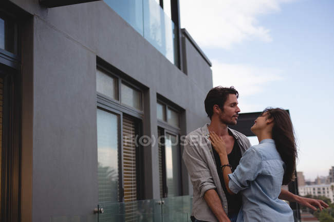 Casal abraçando uns aos outros na varanda em casa — Fotografia de Stock