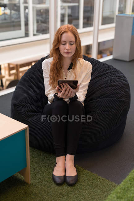 Young female executive using digital tablet in office — Stock Photo