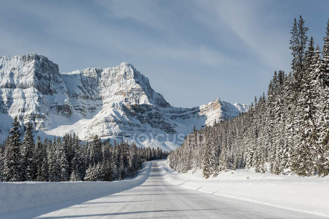 Estrada nevada através da montanha coberta de neve durante o inverno — Fotografia de Stock