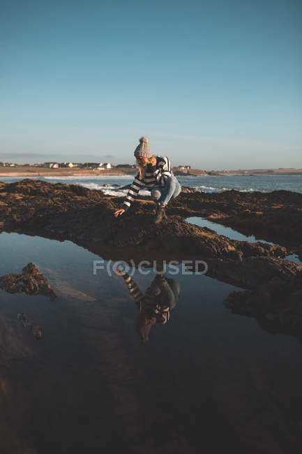 Frau spielt an einem sonnigen Tag mit Wasser am Strand — Stockfoto