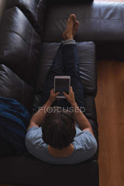 Mann nutzt digitales Tablet im heimischen Wohnzimmer — Stockfoto