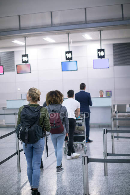 Commuters standing in queue for check-in at airport — Stock Photo