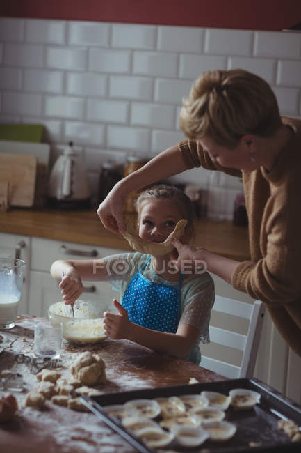 Mother and daughter preparing cupcake in kitchen at home — Stock Photo