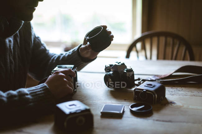 Mittelteil des Menschen repariert eine Kamera zu Hause — Stockfoto