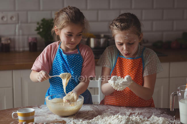 Братья и сестры готовят кексы на кухне дома — стоковое фото