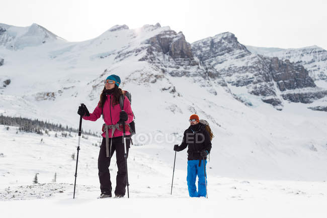 Coppia in piedi su una montagna innevata durante l'inverno — Foto stock