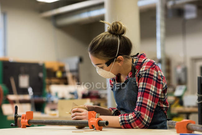Young female carpenter working in workshop — Stock Photo
