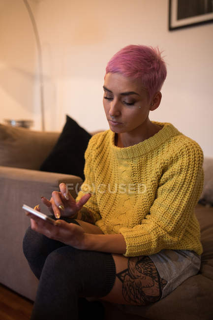 Стильна жінка використовує мобільний телефон вдома — стокове фото